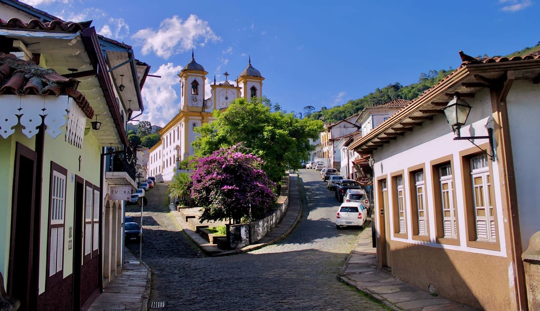 Ladeira de pedra com casarões coloniais e igreja ao fundo em Ouro Preto, Minas Gerais